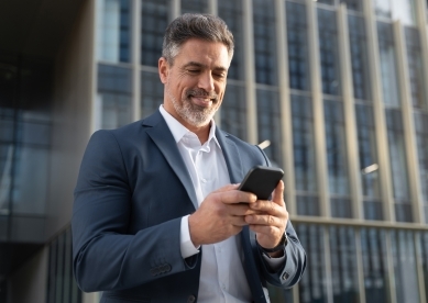 Successful mature Hispanic senior business man using smartphone cellphone